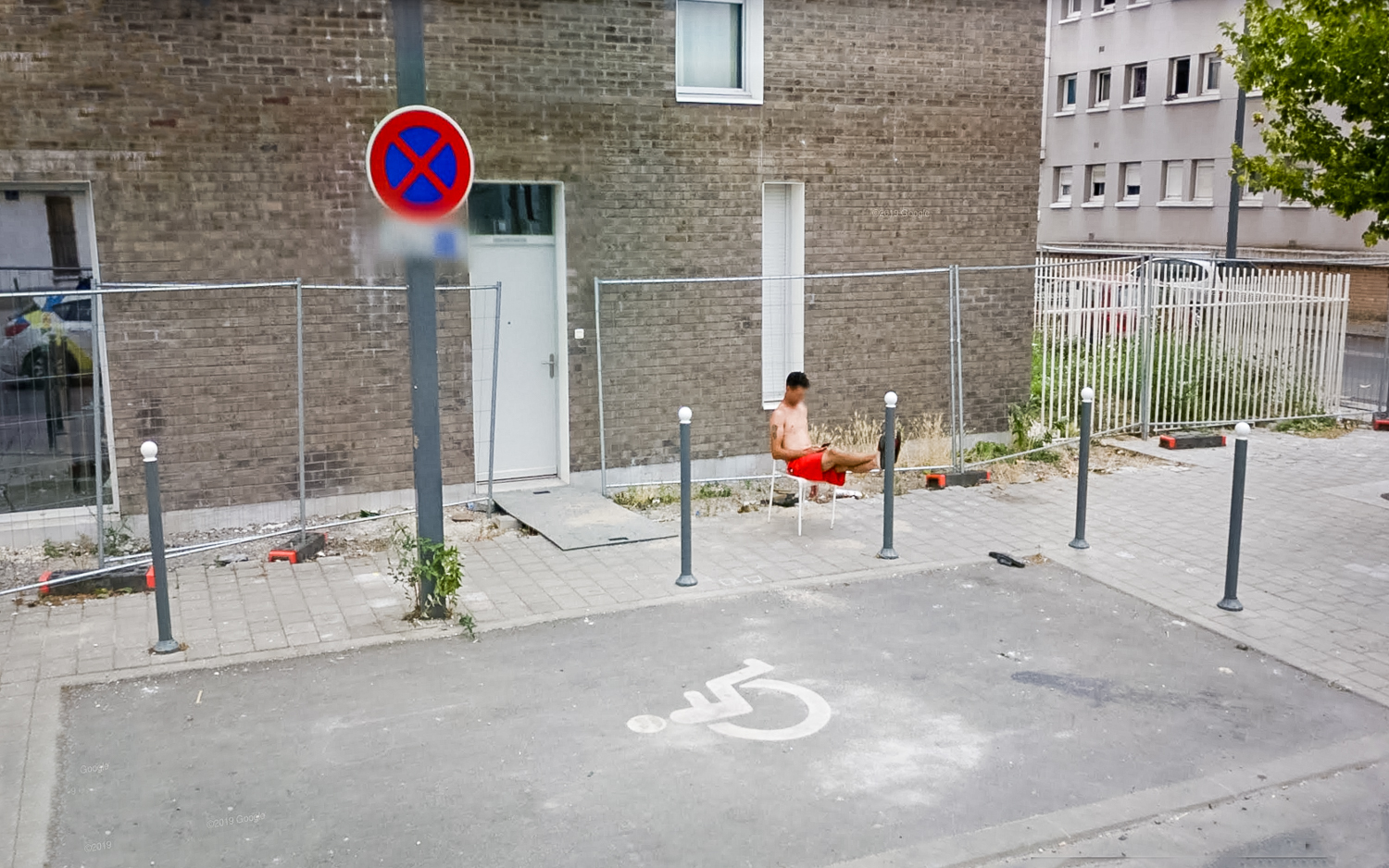 à Lille, un homme torse nu assis sur une chaise dehors